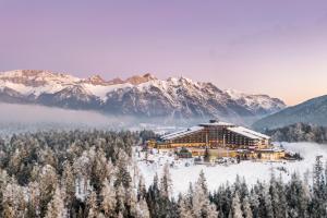 eine Ski-Lodge in den Bergen mit schneebedeckten Bäumen in der Unterkunft Interalpen-Hotel Tyrol in Seefeld in Tirol