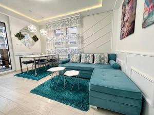 a living room with a blue couch and a table at Apartmani SLEEP&JOY in Zlatibor