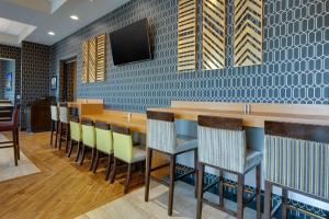 een restaurant met een bar met stoelen en een tv bij Drury Inn & Suites Pittsburgh Airport Settlers Ridge in Pittsburgh