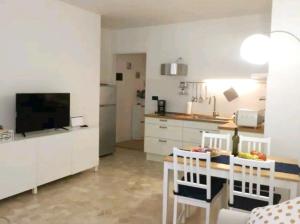 a kitchen with a table with chairs and a television at Casa Pallamaio Historic Center Vicenza in Vicenza