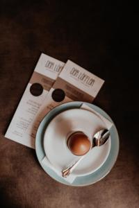 a cup of coffee and a spoon on a newspaper at Der Löffler am Semmering Bed&Breakfast in Semmering