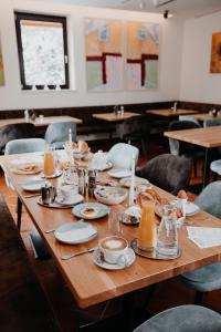 a long wooden table with plates of food on it at Der Löffler am Semmering Bed&Breakfast in Semmering