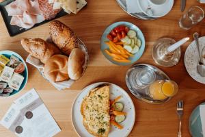 a wooden table topped with plates of food and bread at Der Löffler am Semmering Bed&Breakfast in Semmering