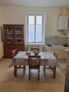 uma cozinha com uma mesa e algumas cadeiras e uma mesa e uma mesa em Maison d'hôtes du Faubourg Charrault Saint Maixent L'Ecole em Saint-Martin-de-Saint-Maixent