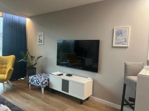 uma sala de estar com uma grande televisão de ecrã plano na parede em SAS & SPA Apartament em Lublin