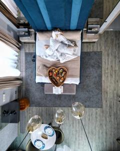 an overhead view of a bed with a table and two wine glasses at Elexus Apartments Poiana Brasov in Poiana Brasov