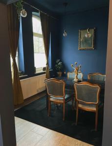 a blue dining room with a table and chairs at Blue Royal Apartment in Celle