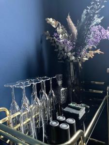 a bunch of wine glasses and a vase with flowers at Blue Royal Apartment in Celle