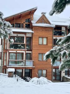 Spacious penthouse chalet apartment in Pirin Golf and Country Club في رازلوغ: مبنى كبير أمامه ثلوج