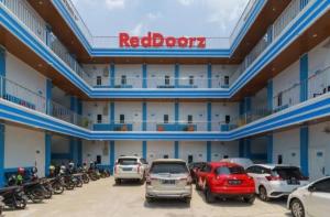 ein großes Gebäude mit Autos auf einem Parkplatz in der Unterkunft RedDoorz Plus near Palembang Icon Mall 2 in Palembang