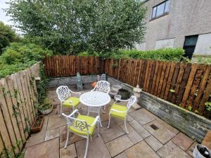 d'une terrasse avec une table, des chaises et une clôture. dans l'établissement Central Westport Town House, à Westport