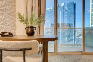 uma mesa com um vaso de plantas num quarto com uma janela em Jewel Suite w/balcony MGM SIGNATURE * 23rd FLOOR* STRIP VIEW em Las Vegas