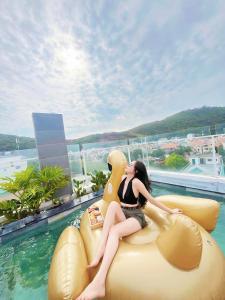 una mujer está sentada sobre un inflable en Nếp Apartment Hotel, en Vung Tau