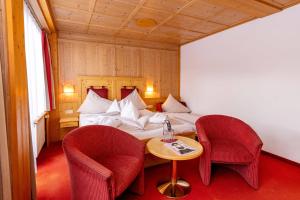 um quarto com uma cama com 2 cadeiras e uma mesa em Hotel Latini em Zell am See