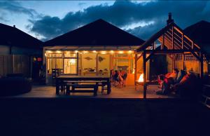 une maison avec une table de pique-nique et un groupe de personnes dans l'établissement West Wittering Family Home, à West Wittering