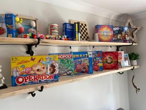 une étagère avec des jouets et des jeux sur elle dans l'établissement West Wittering Family Home, à West Wittering