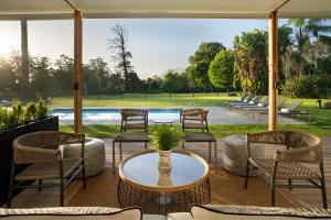 um pátio com cadeiras, uma mesa e uma piscina em Protea Hotel by Marriott George King George em George