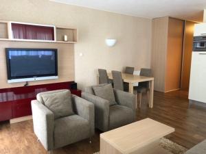 a living room with chairs and a table and a tv at Apartman priamo na svahu in Donovaly