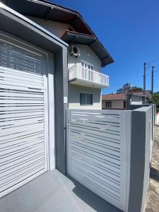 due porte del garage di fronte a una casa di Casa Ampla no Centro, Piso Térreo ou Superior a Bombinhas