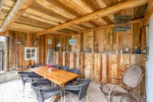 uma sala de jantar com uma mesa de madeira e cadeiras em De Patuljak em Houffalize