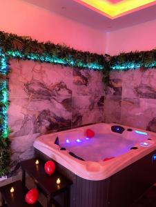 ランゴルサイムにあるSo'Spa appart' jacuzzi & bien-êtreのクリスマスライト付きの客室内のジャクジーバスタブ