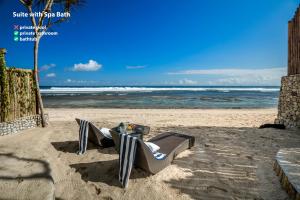 una silla en una playa con el océano en el fondo en Bubble Hotel Nyang Nyang - Adults only, en Uluwatu