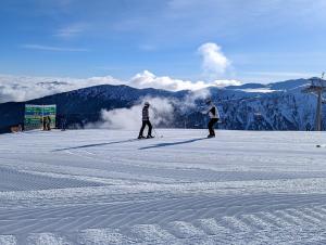 two people are skiing on a snow covered mountain at Park Hotel Panorama in Bansko