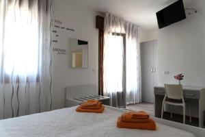 een slaapkamer met een bed met 2 oranje handdoeken erop bij BnB Martin in Jesolo