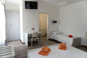 een hotelkamer met 2 bedden, een bureau en een bureau bij BnB Martin in Jesolo