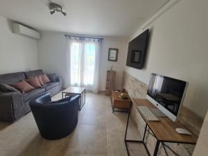 uma sala de estar com um sofá e uma televisão em Appartement Vacances ZEN em Fréjus