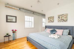 a bedroom with a bed with pink and blue pillows at Spacious 2 Bedroom Loft in Sought After Leslieville in Toronto