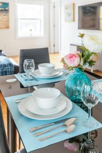 a table with plates and bowls and a vase with flowers at Spacious 2 Bedroom Loft in Sought After Leslieville in Toronto