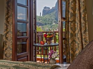 Cette chambre dispose d'un balcon avec une table et des fruits. dans l'établissement Hotel Doupiani House, à Kalambaka