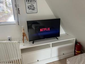 een tv op een wit dressoir bij Chatka pod Lysou in Ostravice