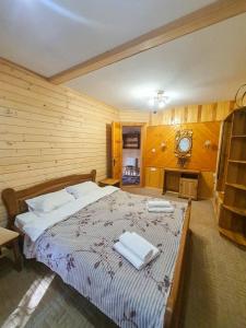 - une chambre avec un grand lit et des serviettes dans l'établissement Готель Ярсон, à Yaremtche