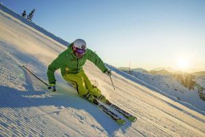 Um homem está a esquiar numa encosta coberta de neve. em Hotel Krvavec em Cerklje na Gorenjskem