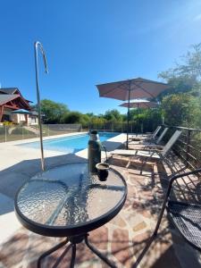 uma mesa com uma garrafa ao lado de uma piscina em Le Bel-Edén em Villa General Belgrano