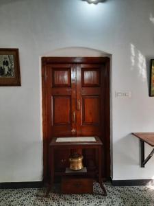 una camera con una porta in legno e un campanello su un tavolo di Heritage Home, Hampe's a Mysore