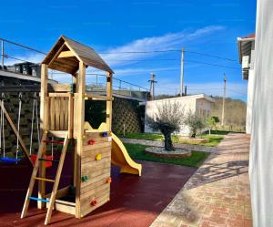 a wooden play set with a slide and a play house at Onix-Vital Apartman Orfű in Orfű