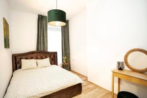 - une chambre avec un lit et un miroir dans l'établissement Central Station Apartment No1, à Kaunas