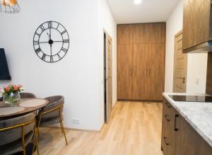 une cuisine avec une table et une horloge murale dans l'établissement Central Station Apartment No1, à Kaunas