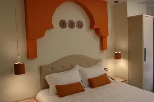 a bedroom with a bed with orange and white pillows at Amman Trail Hotel & Studios in Amman