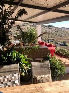 een patio met 2 stoelen en een tafel met planten bij Finca Las Campanas II in Villanueva de la Concepción