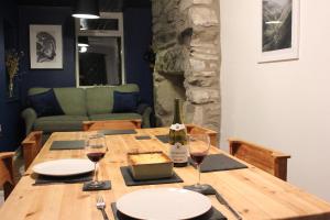 een houten tafel met een fles wijn en glazen bij Terfyn Cottage in Dinorwic