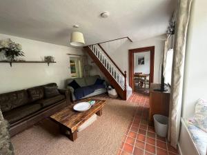 een woonkamer met een bank en een tafel bij Terfyn Cottage in Dinorwic