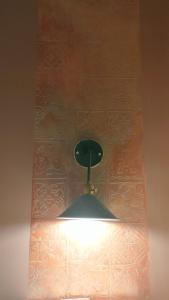 a light hanging from a ceiling with a wall at Maison d'hôtes Dar Ranim Tozeur in Tozeur