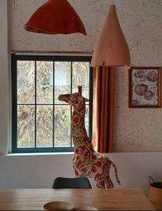 uma estátua de uma girafa numa mesa ao lado de uma janela em Holiday Loft 58 em Arbois