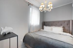 una camera con letto e lampadario a braccio di Saint Andrew Boutique Apartment a Szentendre