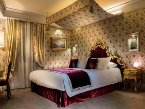 una camera da letto con un grande letto e carta da parati floreale di Hotel Papadopoli Venezia - MGallery Collection a Venezia