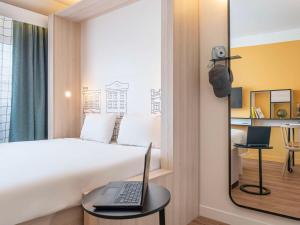 1 dormitorio con cama y mesa con ordenador portátil en Aparthotel Adagio access Hamburg, en Hamburgo